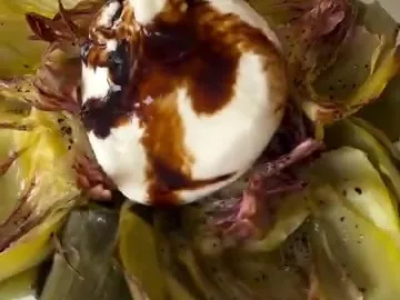 Roasted artichoke opened like a flower with burrata and balsamic in the center