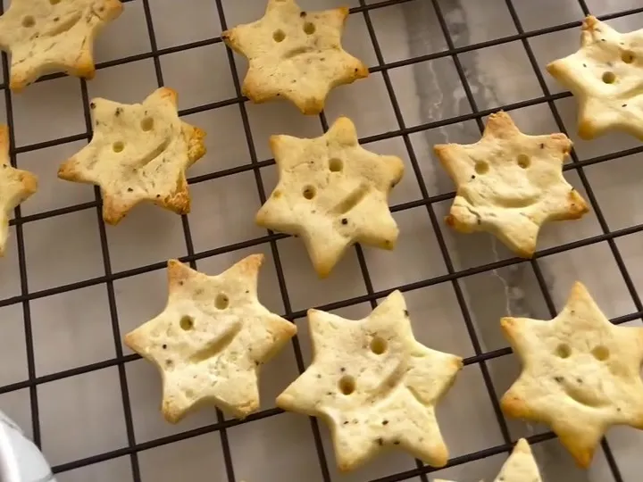Baked star-shaped potato bites with smiley faces on a cooling rack