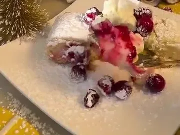 A slice of cranberry and cream cheese shortbread roll dusted with powdered sugar