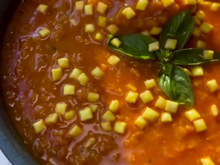 Red lentil tomato soup topped with small croutons and basil