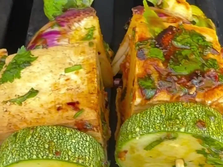 Tofu, zucchini and Brussels sprout skewers on a grill