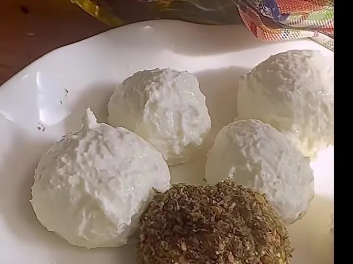Labneh-style cheese balls on a plate, some coated in za’atar and paprika
