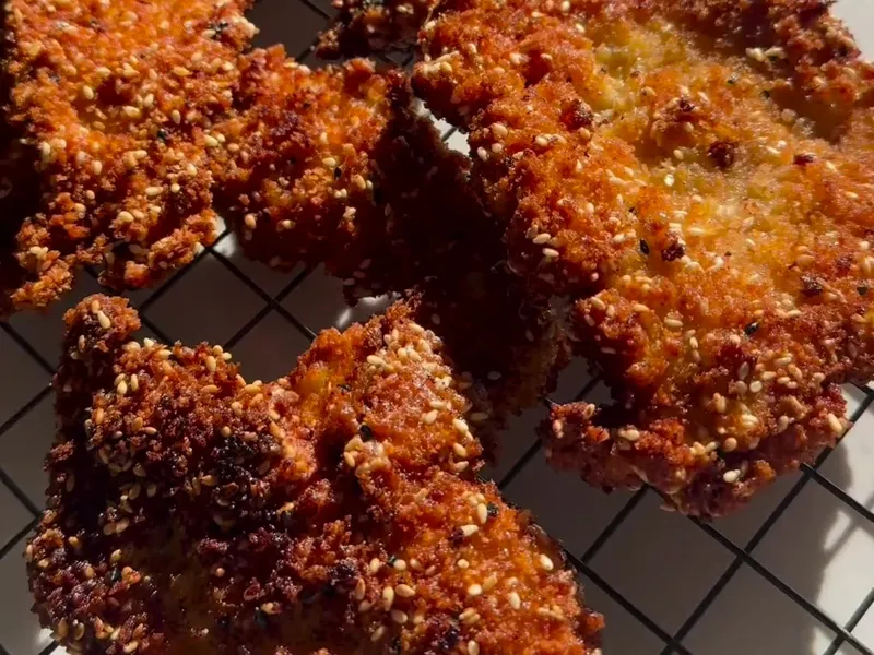 Sesame-crusted crispy chicken schnitzels on a cooling rack