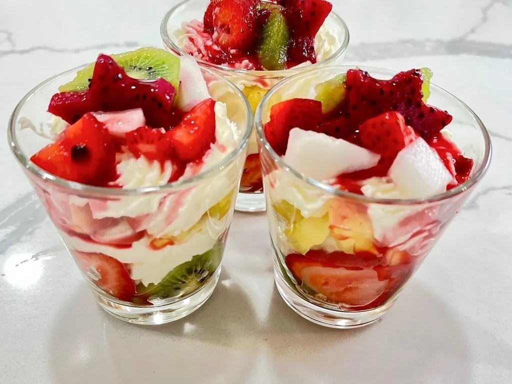 Glasses layered with cut fruit and mascarpone cream