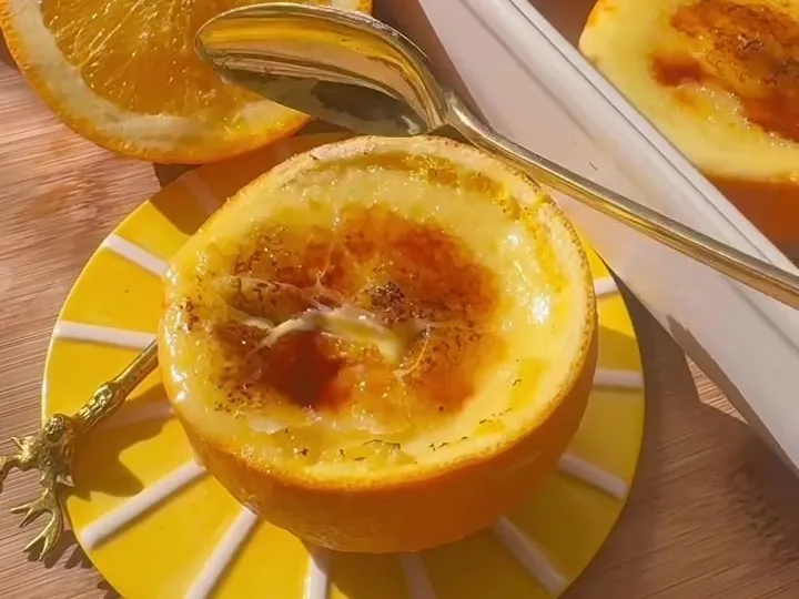 Crème brûlée with a caramelized top served in a halved orange shell