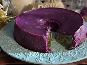 Purple potato crown with a slice cut out, showing the spinach and cheese filling