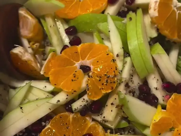 Quinoa salad with green apple sticks, clementine slices and pomegranate seeds