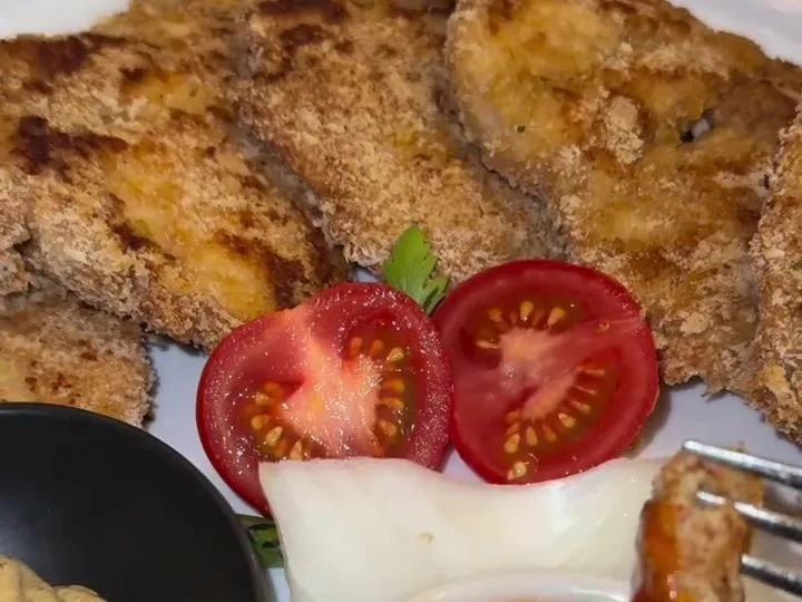 Almond-crusted baked chicken schnitzel with tomatoes, ketchup and mustard