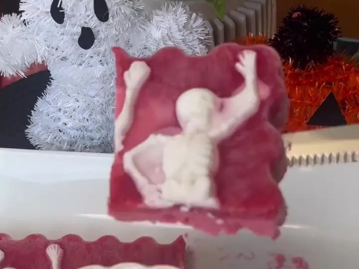 A slice of pink strawberry sorbet with a white coconut skeleton shape on top