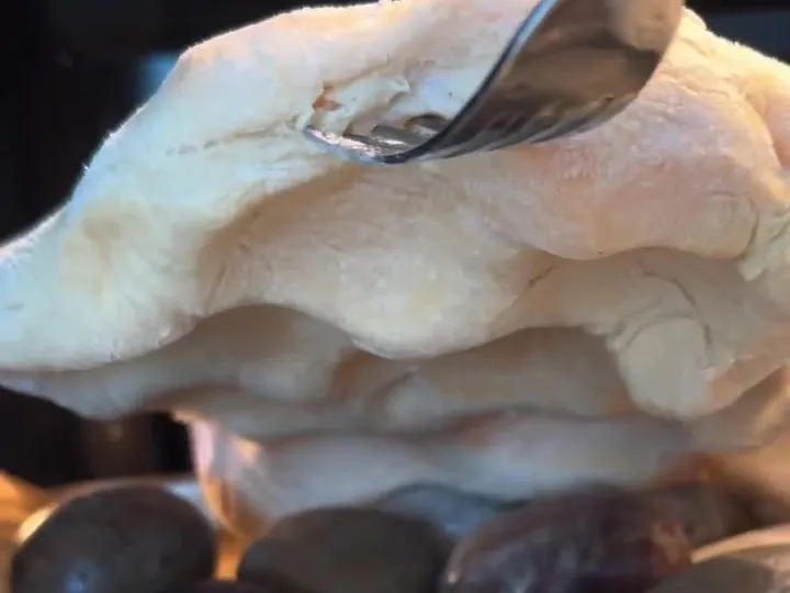 A stack of baked frena flatbreads resting on the hot oven stones