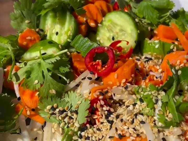 Salad of crinkle-cut carrots, cucumber, bean sprouts, cilantro, chili and sesame seeds